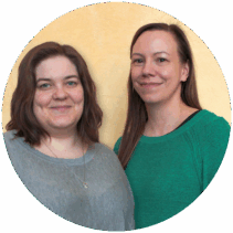 Bild på trakasseriombuden Amanda Ehn och Petra Lindblad som står vid en ljusgul vägg och ler mot kameran