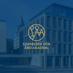 ig-ab-Stiftelsen för åbo akademis logo på blå bakgrund med byggnaden Astra synligt på bakgrunden